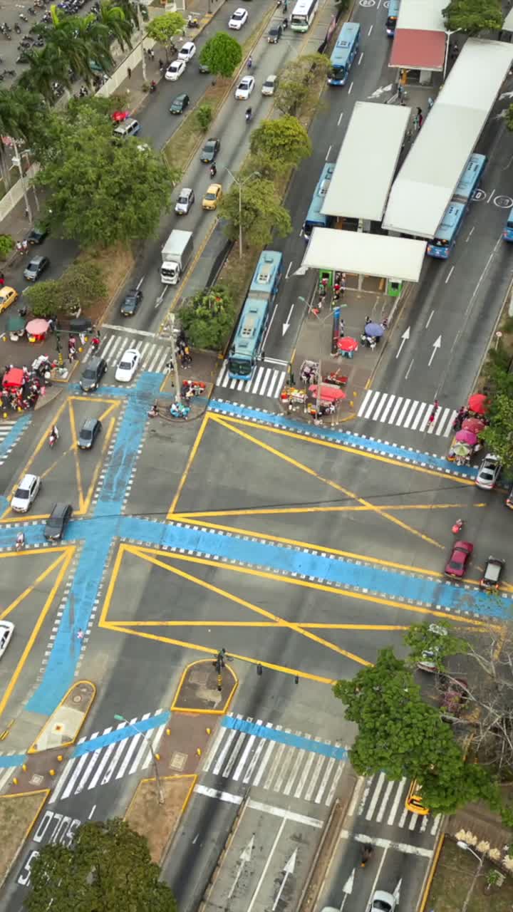 Descending Top View Hyperlapse of Car Traffic at Busy Intersection With MIO Station. Aerial View Cali, Colombia Vertical