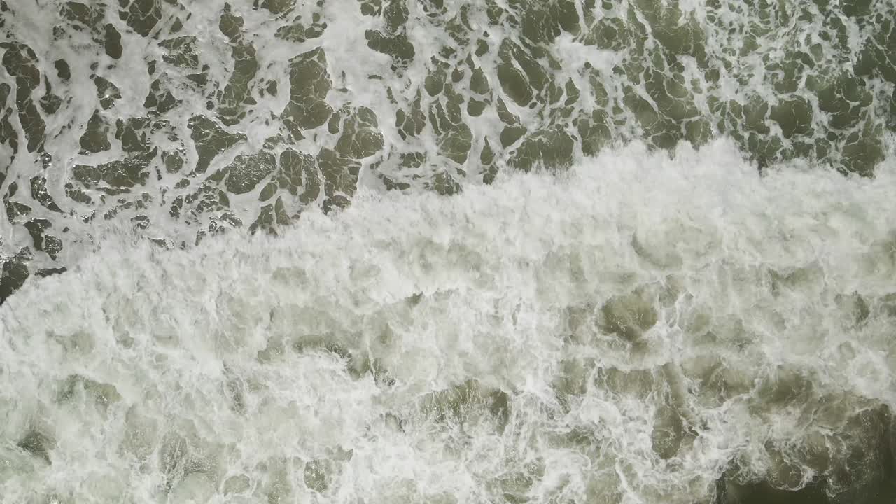Slow-motion waves breaking bottom to top of frame Aerial