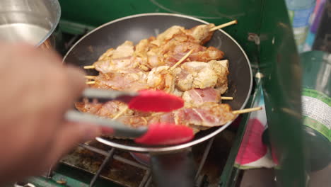 캠프 스토브 위의 뜨거운 팬에 군침이 도는 치킨 수블라키 꼬치 요리