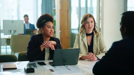 three smiling business people having a meeting in a modern office