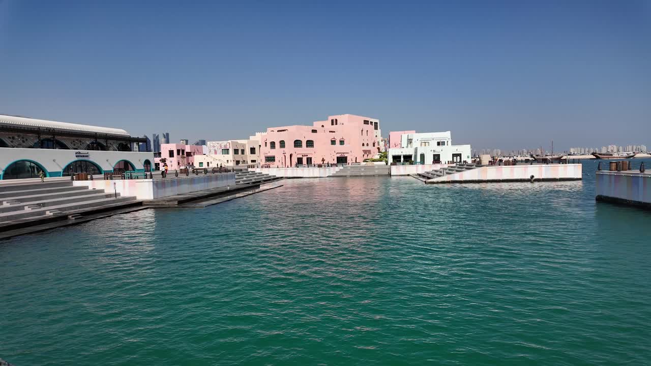 Waterfront promenade with colorful buildings and turquoise water