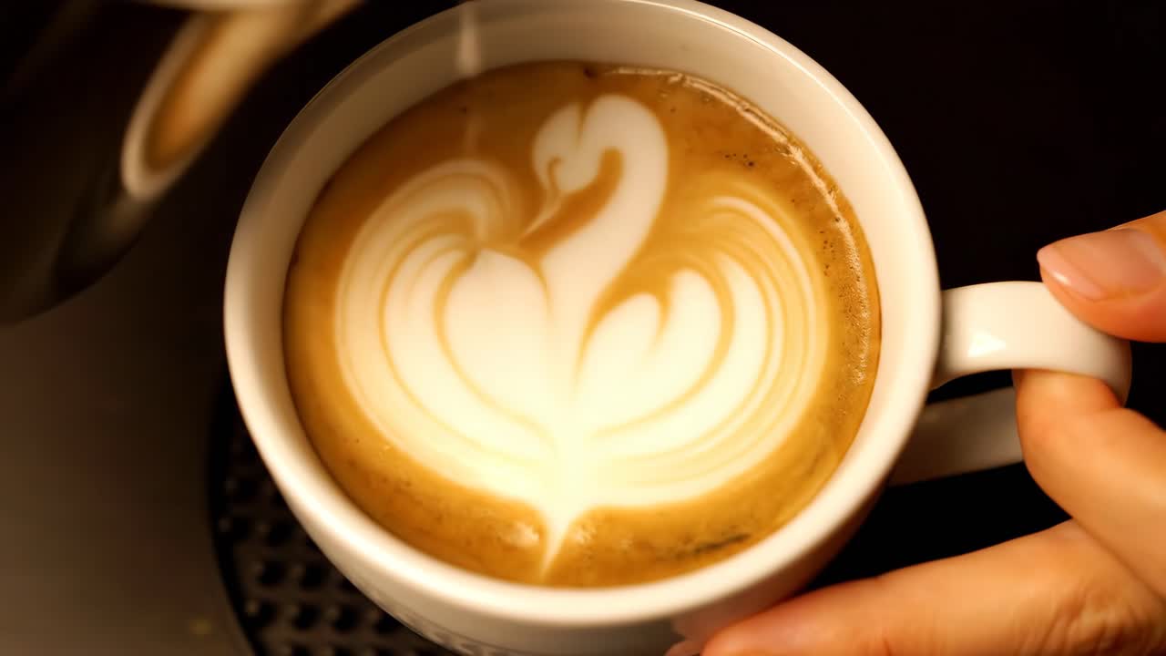 Creating latte art with milk in a cup of coffee