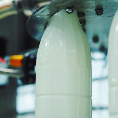 milk is pouring into plastic bottles at a modern food factory. footage of milk bottles at the production line in a milk company. dairy production close-up.