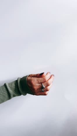 woman's hand with rings and sweater