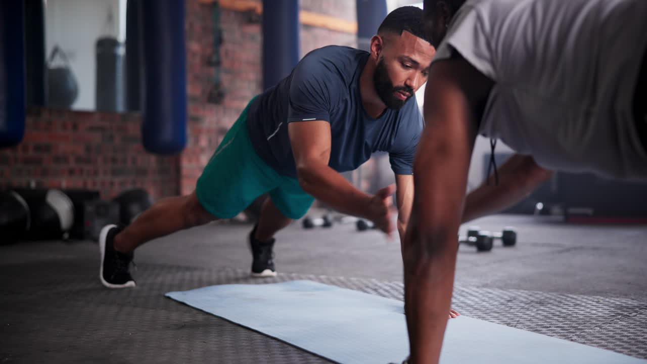 una pareja haciendo flexiones en un gimnasio.