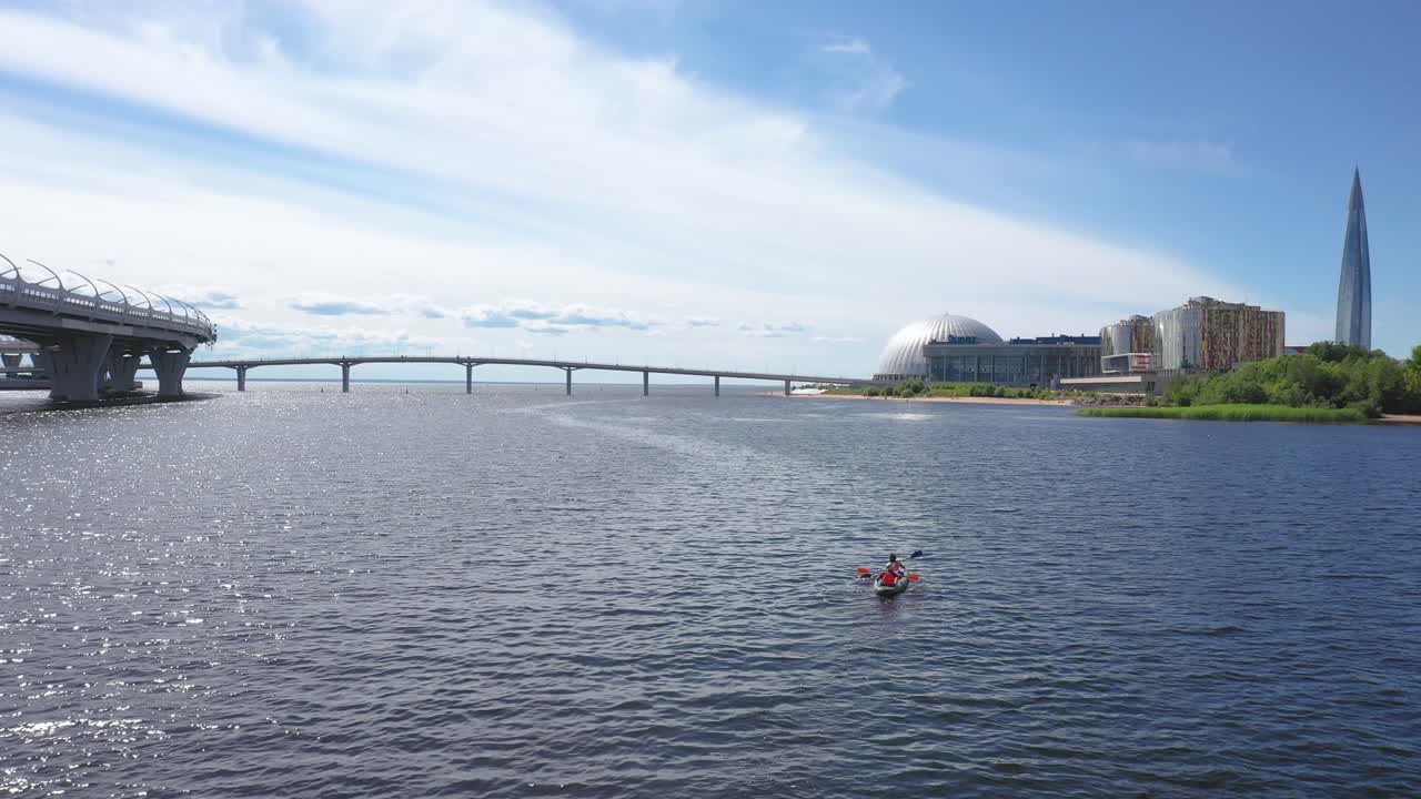 러시아 상트페테르부르크에 있는 핀란드 만 서쪽 고속 직경 다리 아래에서 카약을 타는 두 사람의 공중 드론 추적 샷