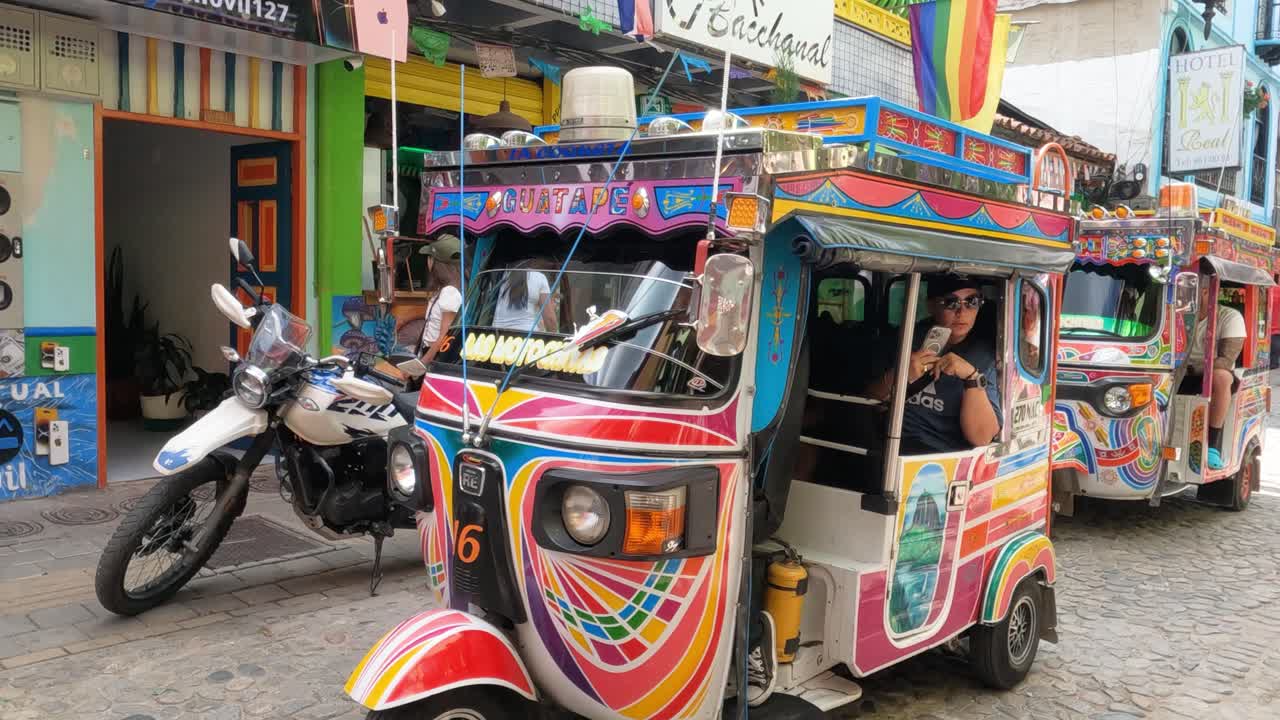 Guatape, Colombia. Tourists Riding in Motochiva, Colombian Version of Tuk Tuk Vehicle, Slow Motion