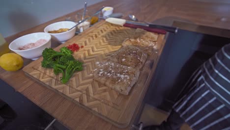 un chef caribeño condimentando el bacalao antes de cocinarlo