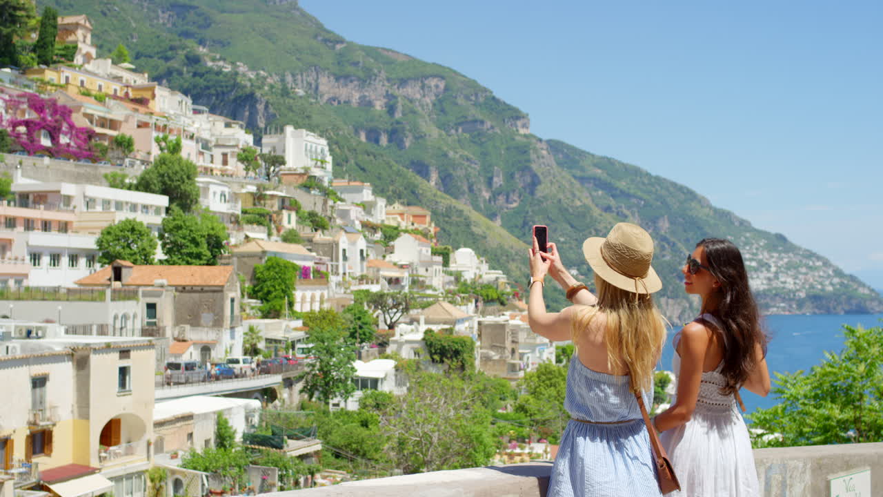 두 친구 가 스마트폰 을 사용 하여 비디오 를 녹화 하고 있다