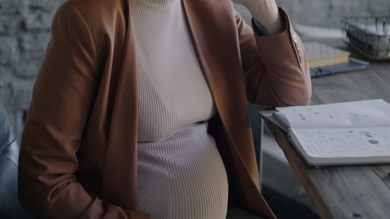 Pregnant Woman and Bald Woman on Phone Calls in Office