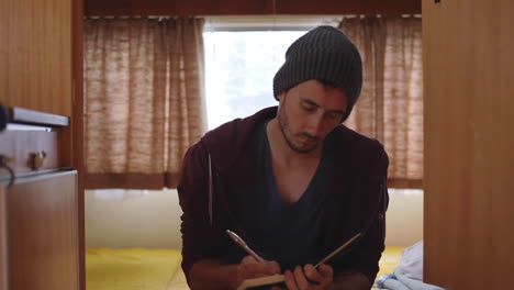 static shot of caucasian man focus on writing inside his van