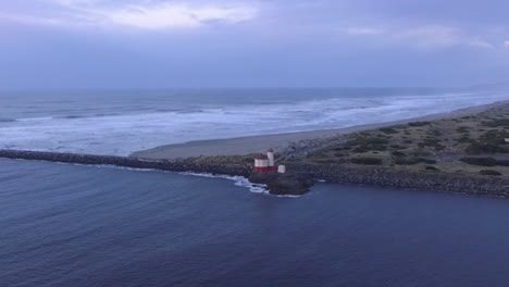 Drohnenaufnahmen-Des-Leuchtturms-Von-Coquille-River,-Aufgenommen-Bei-Sonnenuntergang,-Wo-Der-Pazifische-Ozean-Auf-Die-Küste-Von-Oregon-Trifft