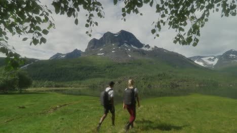 two hikers exploring a scenic mountain and lake landscape
