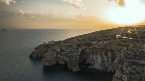 Goldene-Farbtöne-Während-Des-Sonnenuntergangs-über-Dem-Meer-Aus-Der-Blauen-Grotte,-Malta,-Zeitraffer