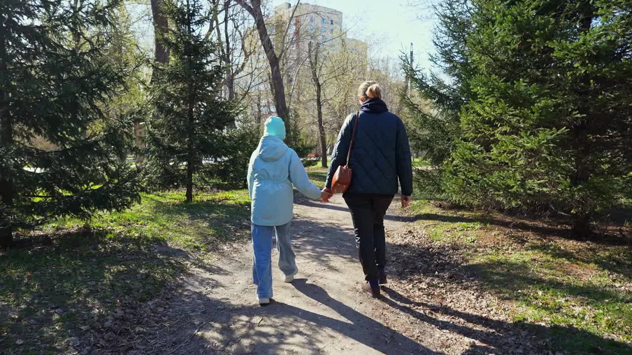 Güneşli Bir Park Yolunda El Ele Yürüyen Anne ve Kız