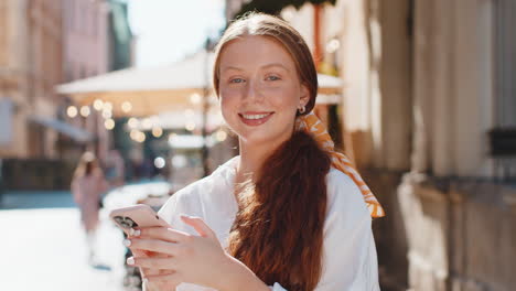 Una-Adolescente-Usa-Un-Teléfono-Inteligente-Para-Escribir-Mensajes-De-Texto,-Navegar-Por-Internet-Y-Terminar-Su-Trabajo-Mientras-Mira-A-La-Cámara