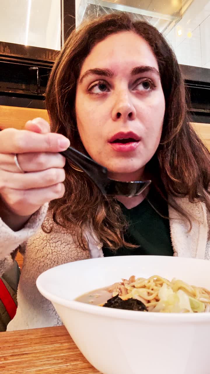 Donna che gusta deliziosi ramen al ristorante.