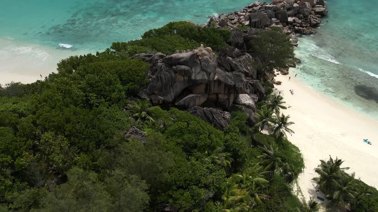 Pemandangan di pulau La Digue di Seychelles direkam dengan drone dari atas menampilkan samudra, bebatuan, dan pohon kelapa.