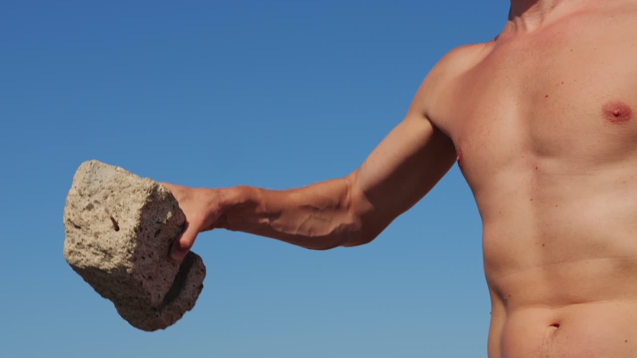 Man lifting a rock outdoors
