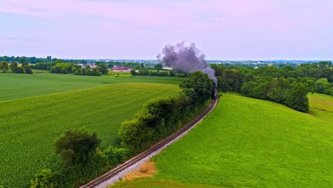 Una-Vista-Aérea-De-Un-Antiguo-Tren-De-Pasajeros-De-Vapor-Que-Sopla-Humo-Negro-A-Través-De-Las-Tierras-Agrícolas-De-Pensilvania