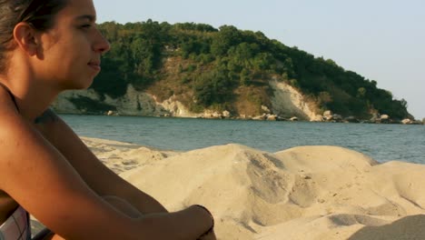 Mädchen-Sitzt-Am-Strand-Und-Starrt-Auf-Das-Meer