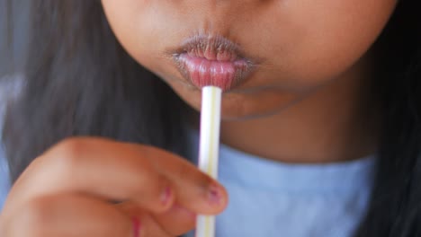 una chica bebiendo de una pajita.