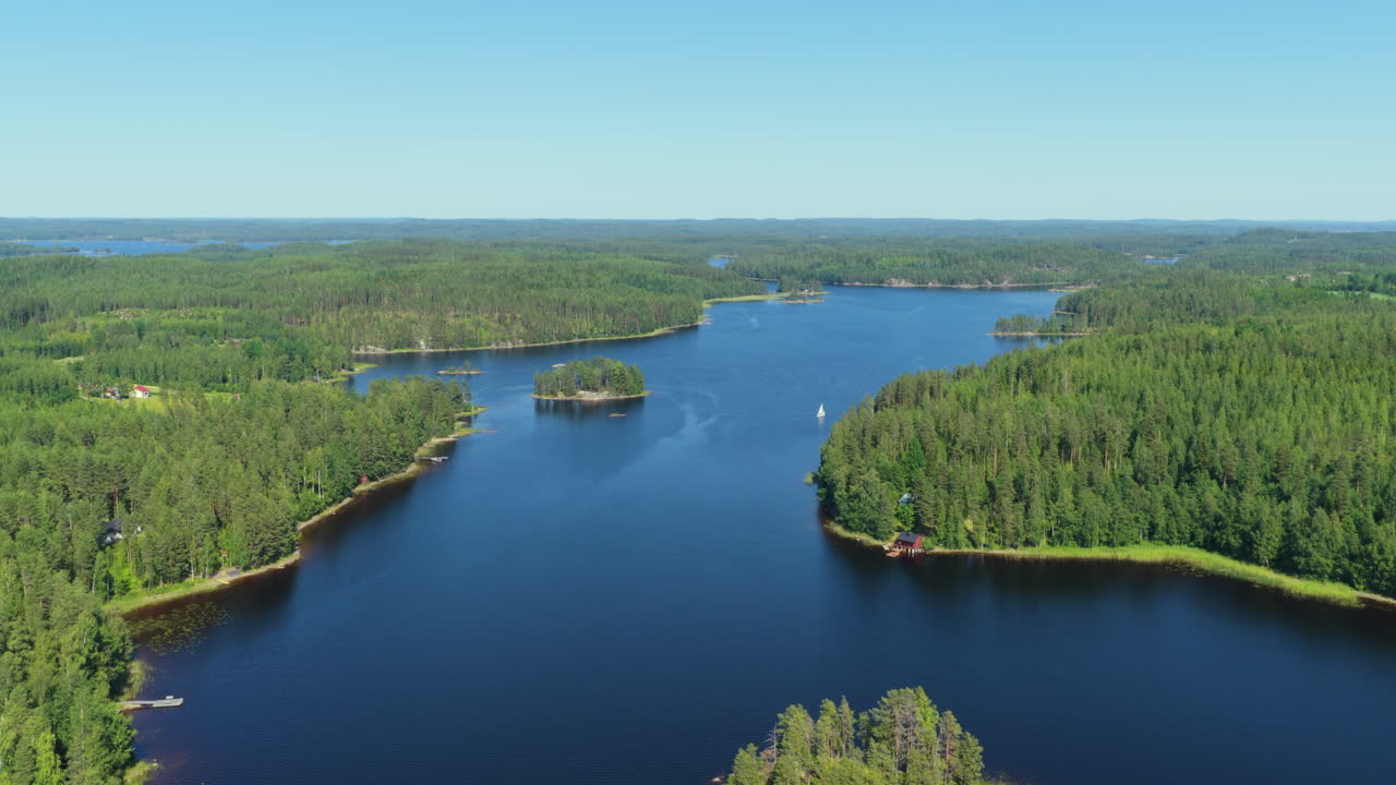 Establishing aerial of a sailboat on lake Leikonvesi, summer in Saimaa, Finland