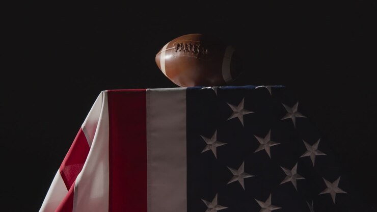 zurückhaltende beleuchtungsstudioaufnahme des american football auf der stars and stripes-flagge 8