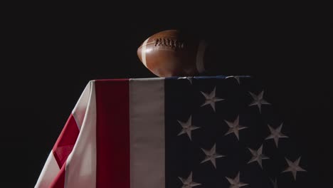 Low-Key-Lighting-Studioaufnahme-Des-American-Football-Auf-Der-Stars-And-Stripes-Flagge-8