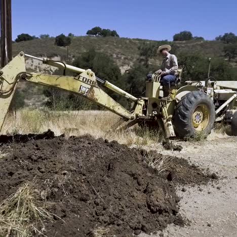 Backhoe-tractor-digging-up-a-leaking-water-line-on-a-hot-day-7