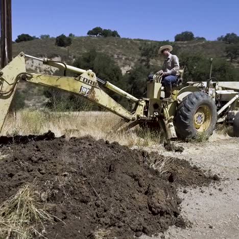 tractor retroexcavadora desenterrando una línea de agua con fugas en un día caluroso-7