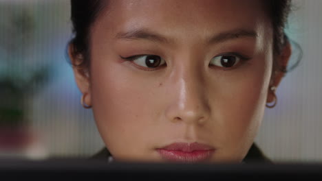 close-up-portrait-beautiful-asian-business-woman-working-late-using-tablet-computer-browsing-financial-graph-data-looking-at-information-on-screen-wearing-glasses