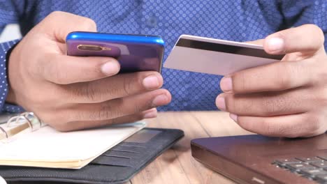 person using mobile phone and credit card for online payment