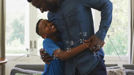 father hugging son in living room with windows, showing technology data visualization icons