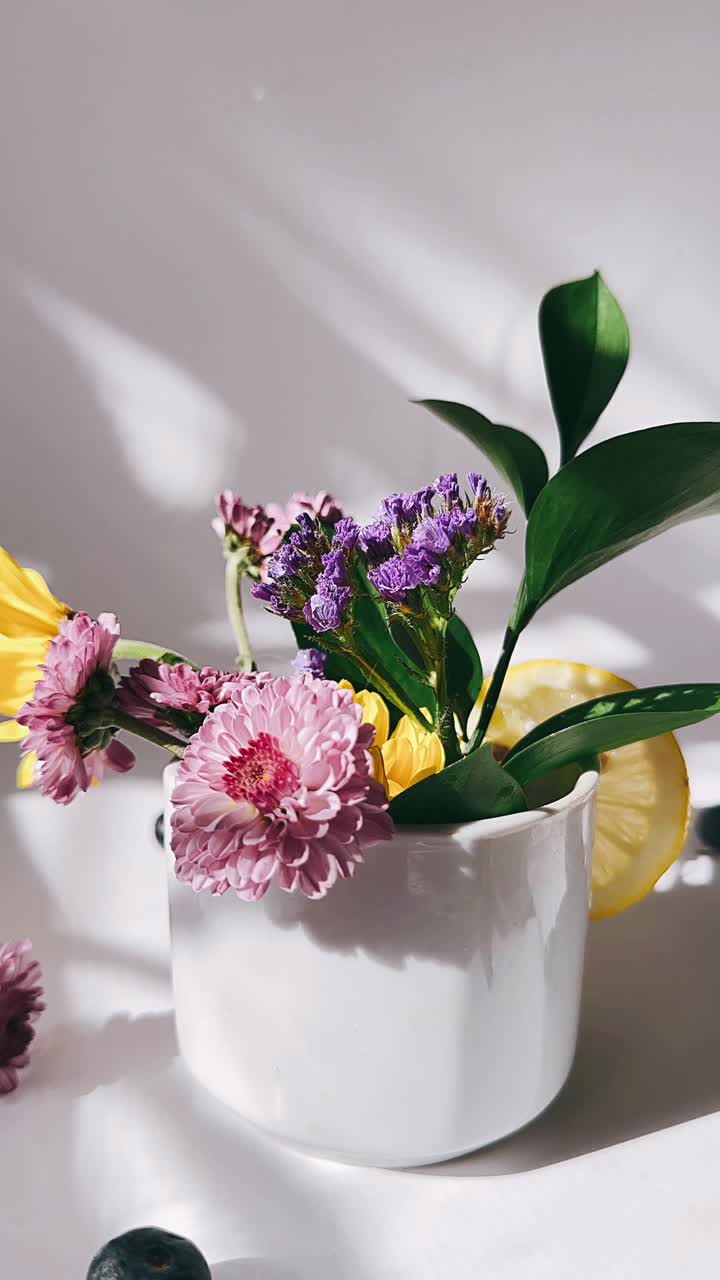 arreglo floral en cuenco blanco con limón y arándanos