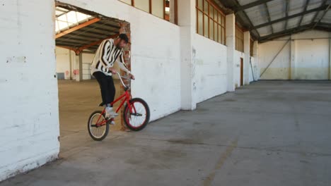 bmx riders in an empty warehouse