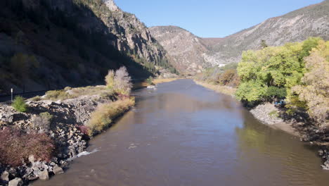 Colorado-river-in-the-heart-of-Glenwood-Springs-canyon-resort,-United-States-Drone-shot-of-the-Colorado-River-flowing-through-the-town-of-Glenwood-Springs