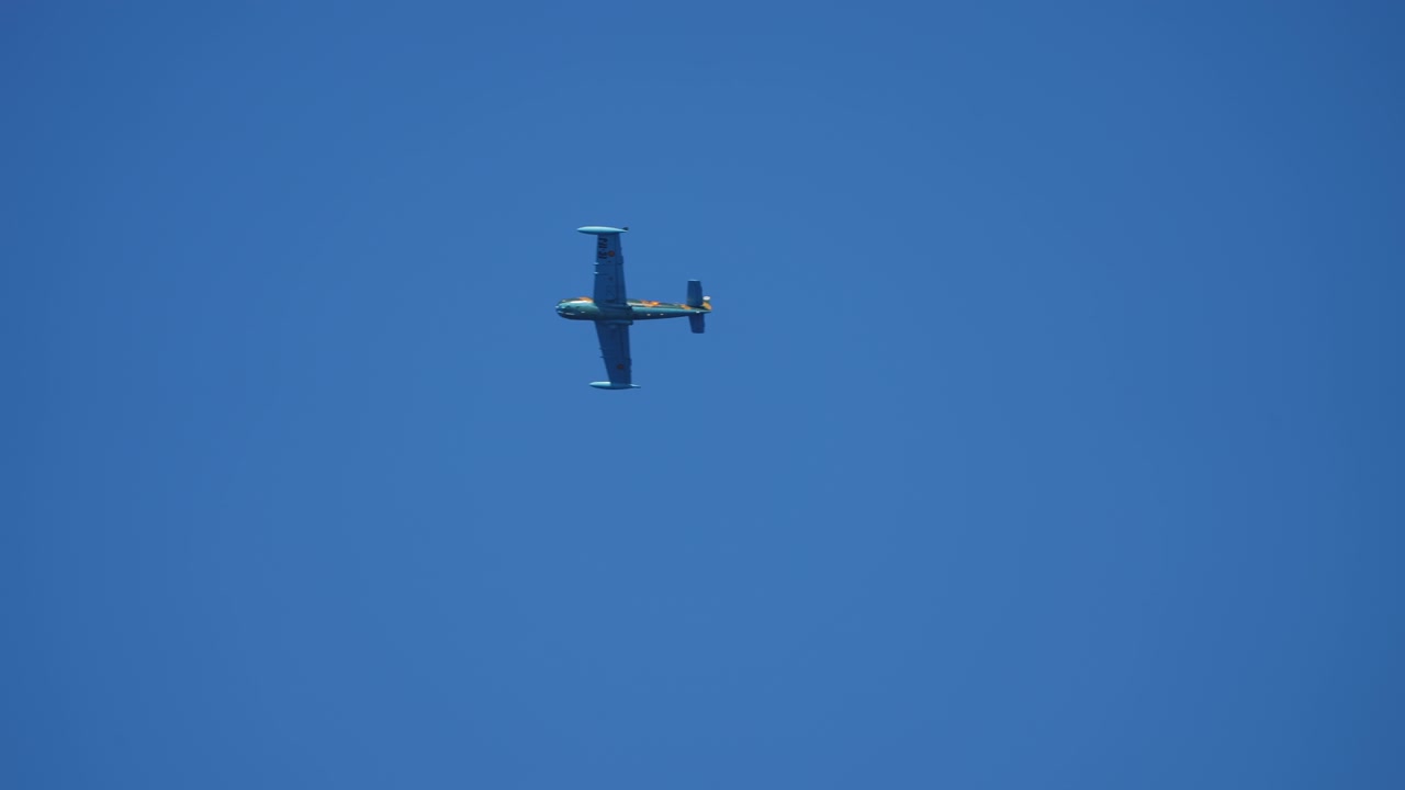 Militært propelfly udfører en rulning på blå himmel.