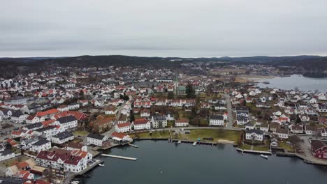 Lillesand-upward-moving-aerial-with-slow-tilt-down---Town-view-with-Lillesand-church-in-center-of-frame