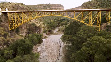 Drohnenvideo-Einer-Brücke-Auf-Der-Autobahn-Und-Unterhalb-Eines-Flusses-Zwischen-Den-Von-Bäumen-Umgebenen-Bergen-In-Zimapan-Hidalgo,-Mexiko