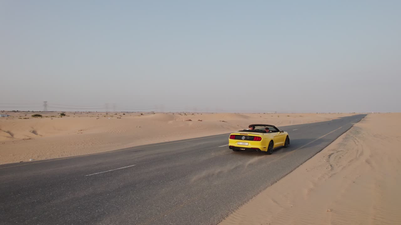 사막 도로에서 노란색 컨버터블 머스