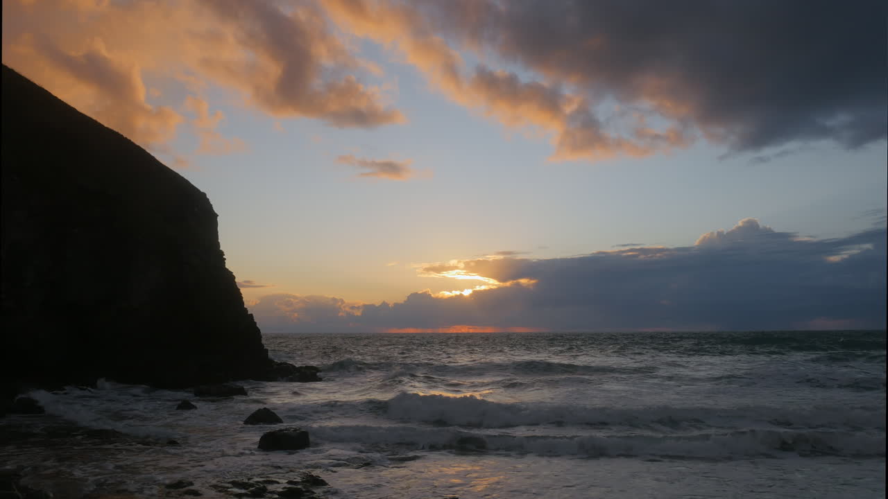 vista del paisaje marino de la marea de principios de otoño con hermosos cielos y olas rompiendo contra las rocas