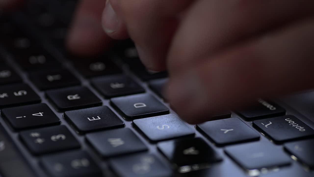 A close-up shot of fingers typing on a laptop keyboard. The shallow depth of field highlights the keys and the movement of the hands, creating a focused and dynamic atmosphere