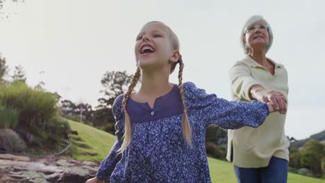 little girl holding grandmother hand and running in the garden 4k 4k