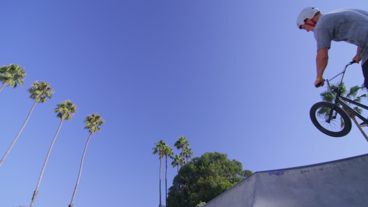 vista de ángulo bajo de un ciclista bmx ejecutando un salto en un skatepark 1