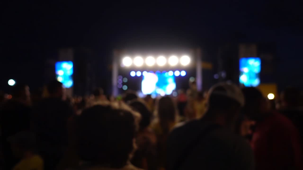 Concerto sul palco. Folla di persone e musicisti sulla scena. Fuori fuoco