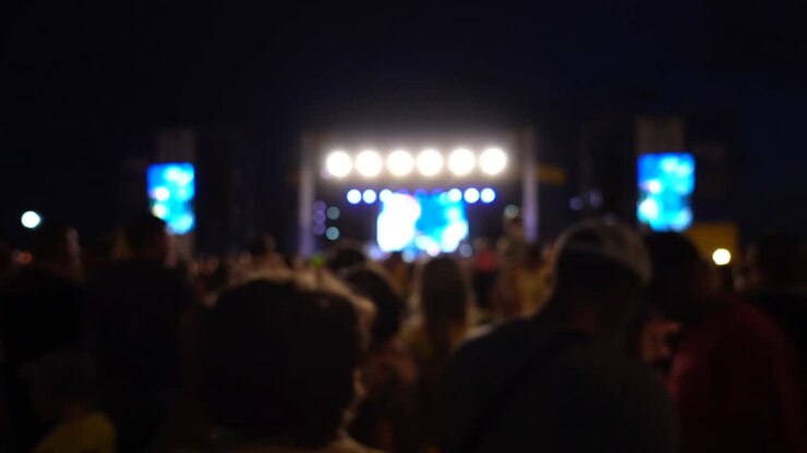 Concerto sul palco. Folla di persone e musicisti sulla scena. Fuori fuoco