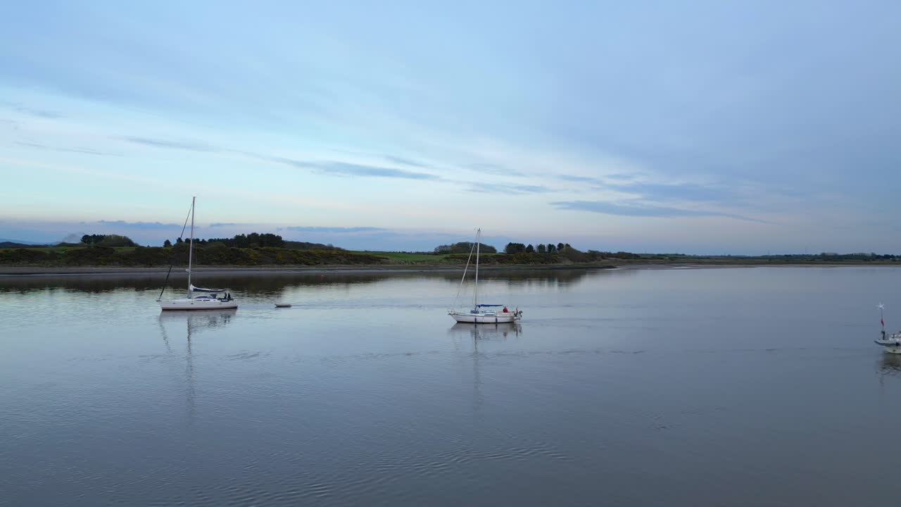 volando sobre yates en aguas tranquilas al anochecer en el estuario del río wyre fleetwood lancashire reino unido