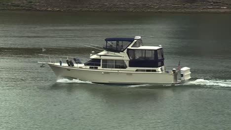 Small-white-yacht-boat-cruising-on-a-river-during-the-day