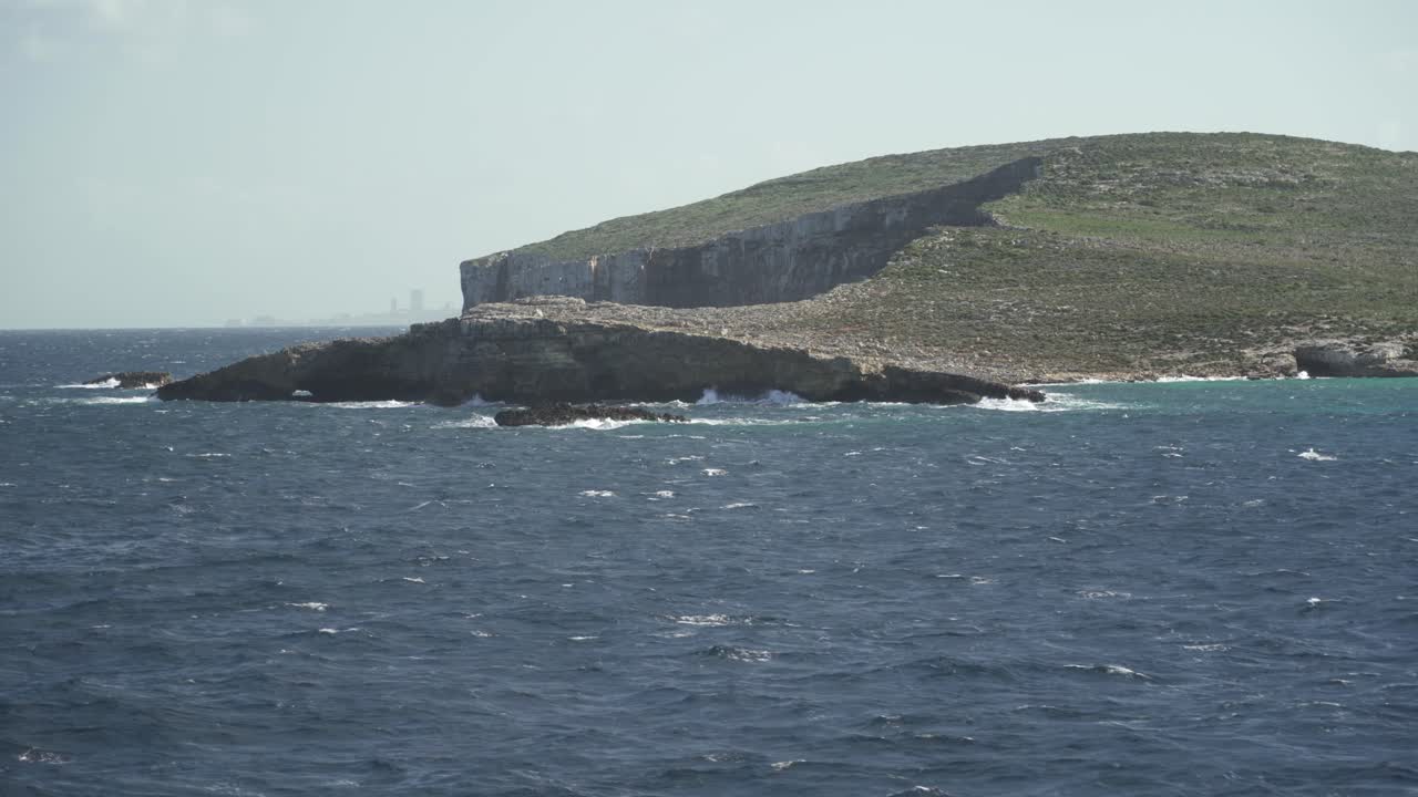 el mar mediterráneo lava las costas de la isla de comino durante el invierno en un día soleado y ventoso